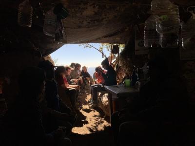 Det internationale forskerhold har sat sig i indgangen til hulen. Nu spises der frokost, inden der igen skal graves.